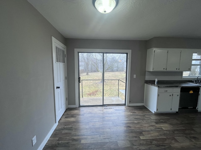 kitchen featuring white cabinetry, sink, black dishwasher, and dark wood-type flooring