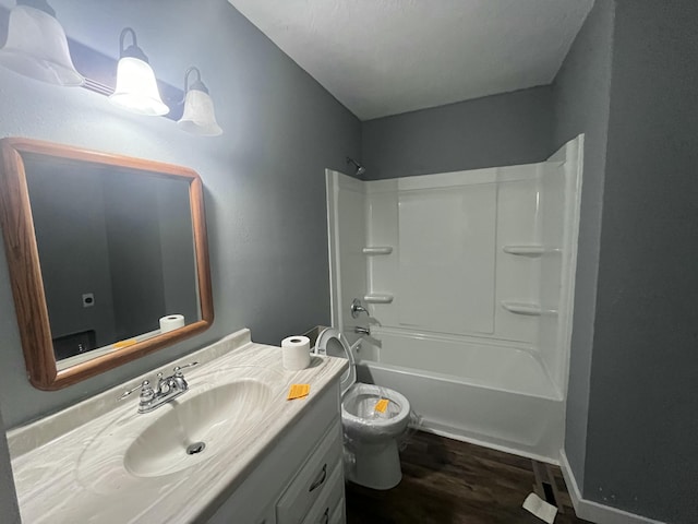 full bathroom featuring vanity, hardwood / wood-style floors, shower / tub combination, and toilet