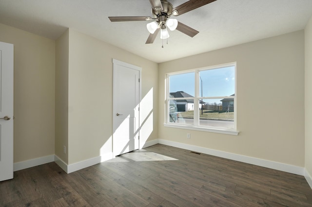 empty room featuring ceiling fan and dark hardwood / wood-style flooring