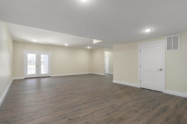 unfurnished room featuring dark wood-type flooring, french doors, and a textured ceiling