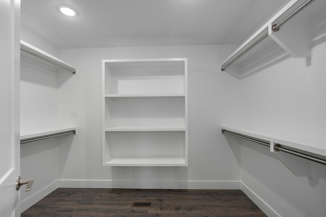 spacious closet featuring dark hardwood / wood-style floors