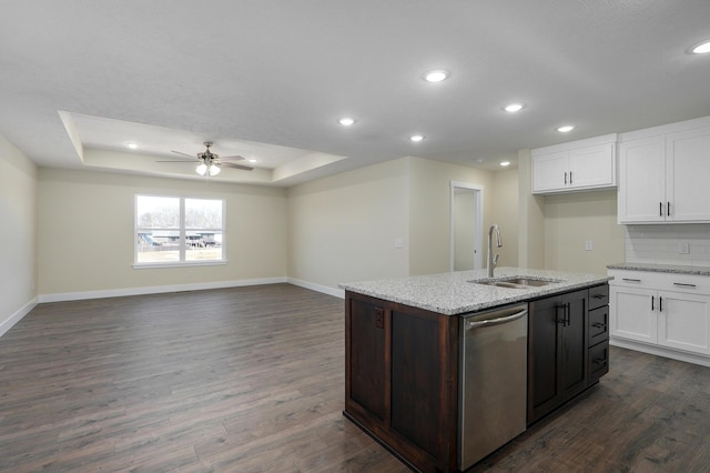 kitchen featuring sink, stainless steel dishwasher, dark hardwood / wood-style floors, a raised ceiling, and a kitchen island with sink