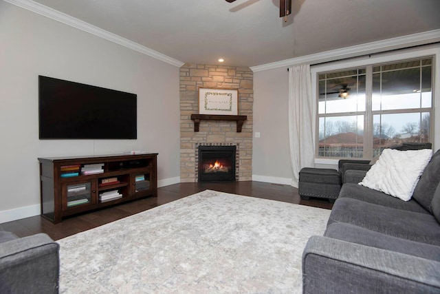 living room featuring ornamental molding, dark hardwood / wood-style flooring, a stone fireplace, and ceiling fan