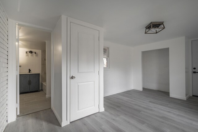 corridor featuring sink and light hardwood / wood-style flooring