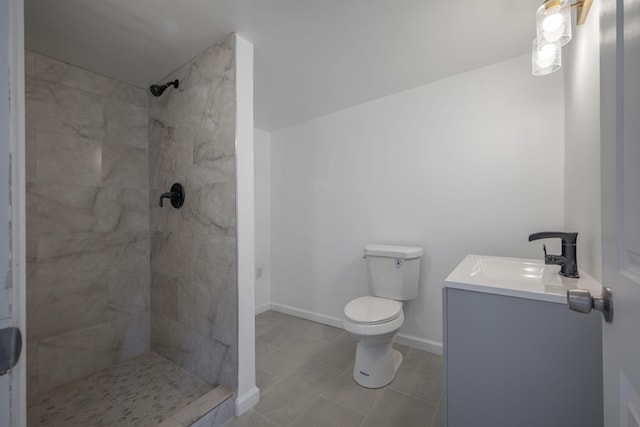 bathroom featuring tile patterned floors, vanity, toilet, and a tile shower