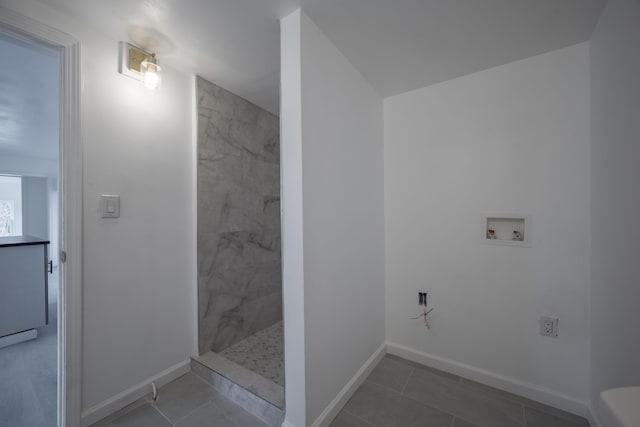 bathroom with a tile shower and tile patterned floors