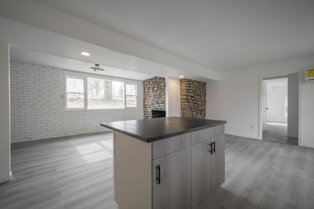 kitchen with light hardwood / wood-style floors, a center island, and brick wall
