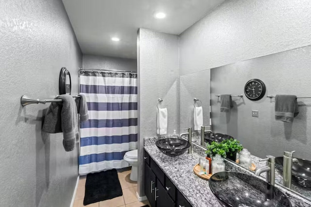 bathroom featuring tile patterned flooring, vanity, toilet, and walk in shower