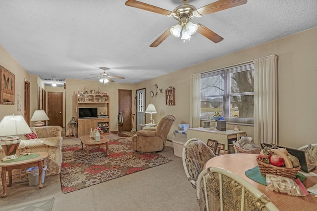 living room with ceiling fan, light colored carpet, and a textured ceiling