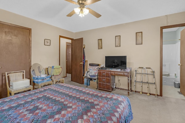 carpeted bedroom with ceiling fan and ensuite bathroom