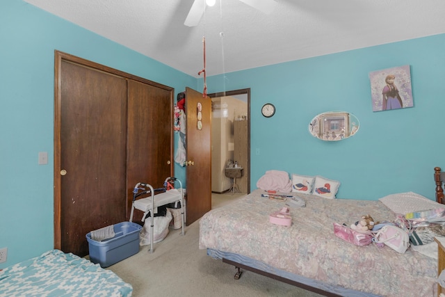 carpeted bedroom featuring a closet and ceiling fan