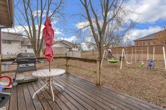 wooden terrace with area for grilling and a playground