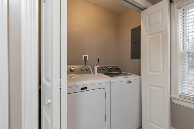 clothes washing area with washer and clothes dryer and electric panel