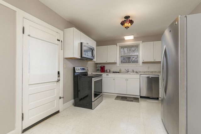 kitchen with stainless steel appliances, sink, white cabinets, and backsplash