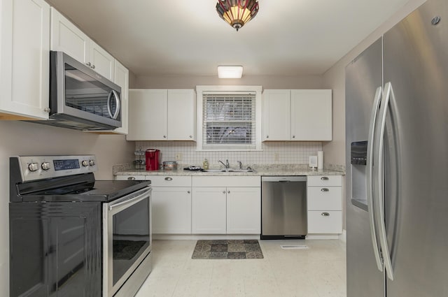 kitchen featuring white cabinetry, sink, light stone counters, and stainless steel appliances