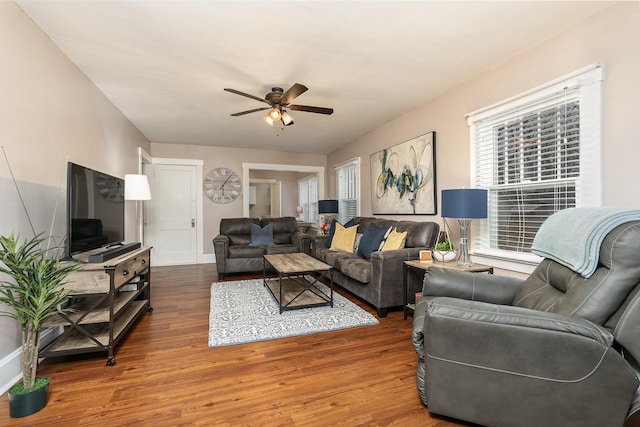 living room featuring dark wood-type flooring and ceiling fan