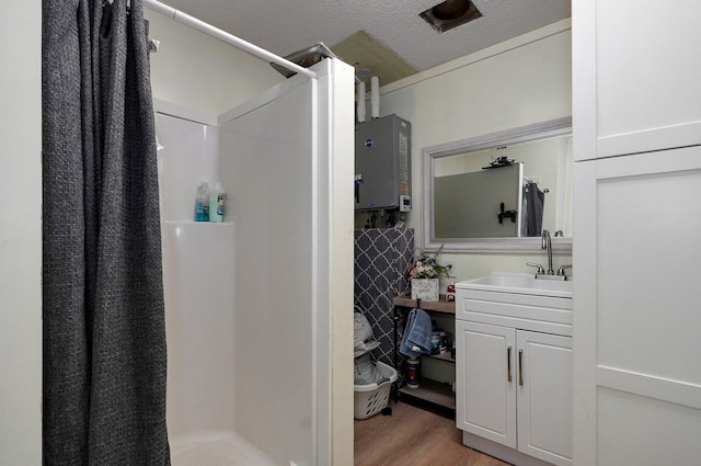 bathroom featuring vanity, wood-type flooring, water heater, and a shower