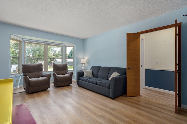 living room with a textured ceiling and light wood-type flooring