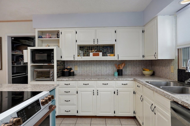 kitchen featuring sink, light tile patterned floors, appliances with stainless steel finishes, white cabinetry, and backsplash