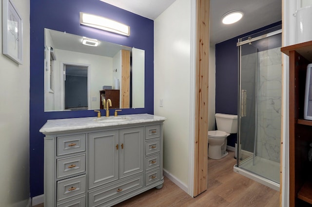 bathroom featuring walk in shower, vanity, toilet, and hardwood / wood-style flooring