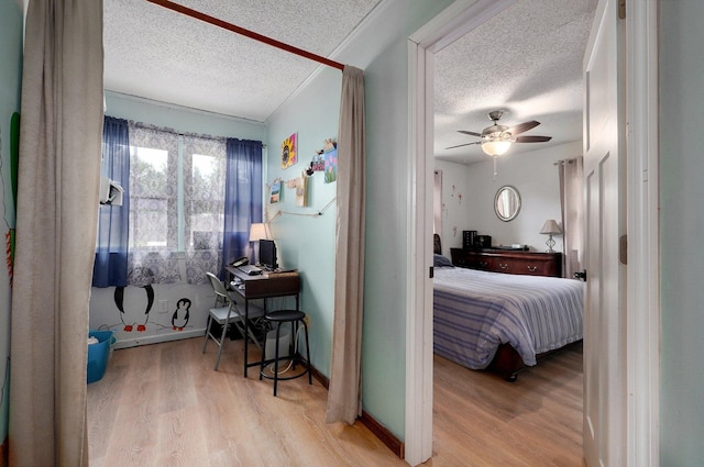 bedroom featuring ceiling fan, light hardwood / wood-style floors, and a textured ceiling