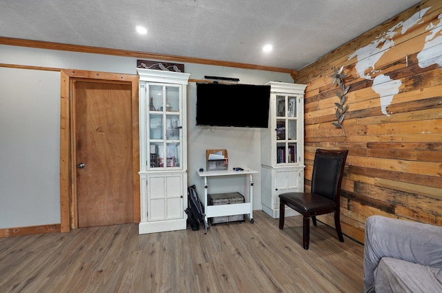 living area with crown molding and hardwood / wood-style floors