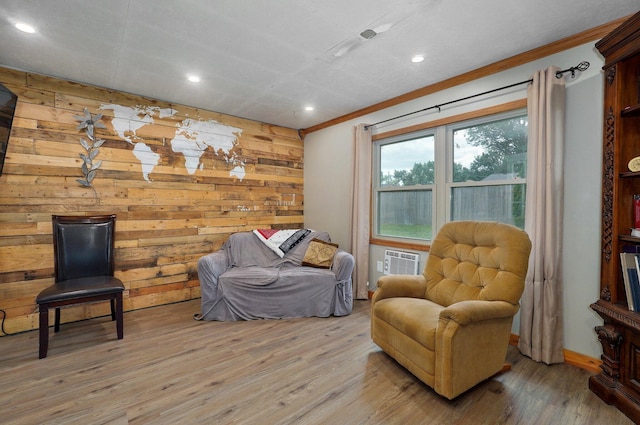 living area featuring a wall unit AC, light hardwood / wood-style flooring, and wood walls