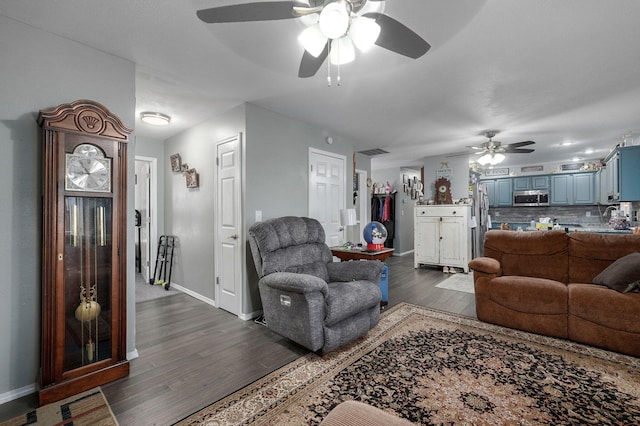 living room featuring dark wood-type flooring and ceiling fan