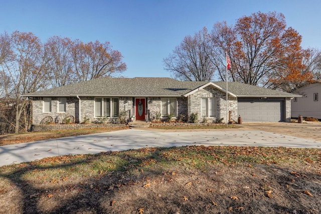 ranch-style home with concrete driveway, a shingled roof, brick siding, and an attached garage
