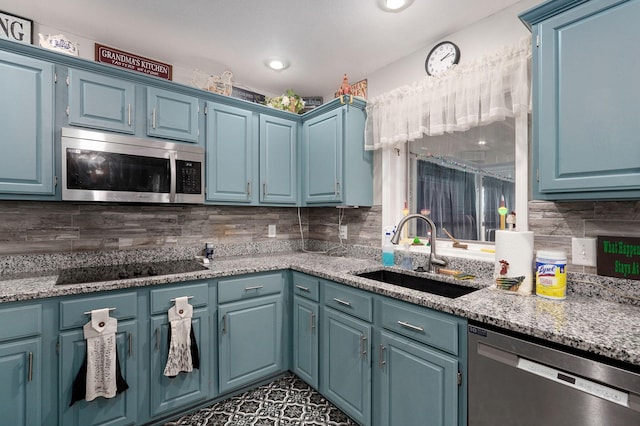 kitchen with blue cabinetry, stainless steel appliances, and sink