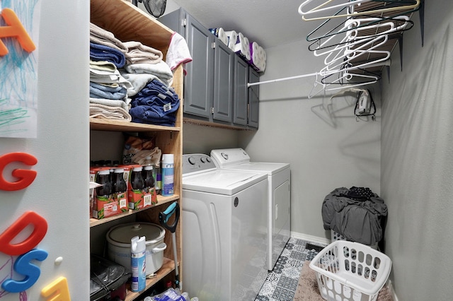 clothes washing area featuring cabinets and separate washer and dryer