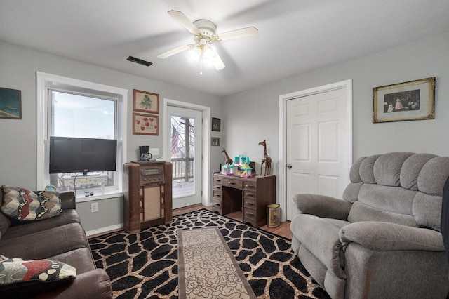 living room with dark hardwood / wood-style floors and ceiling fan