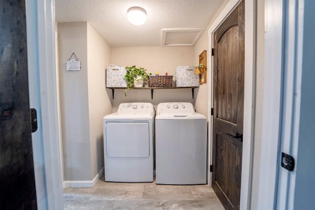 laundry room with washing machine and dryer and a textured ceiling