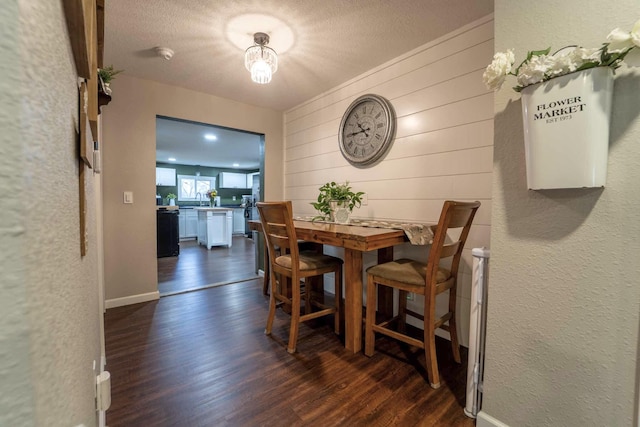 dining area featuring dark hardwood / wood-style flooring and a textured ceiling