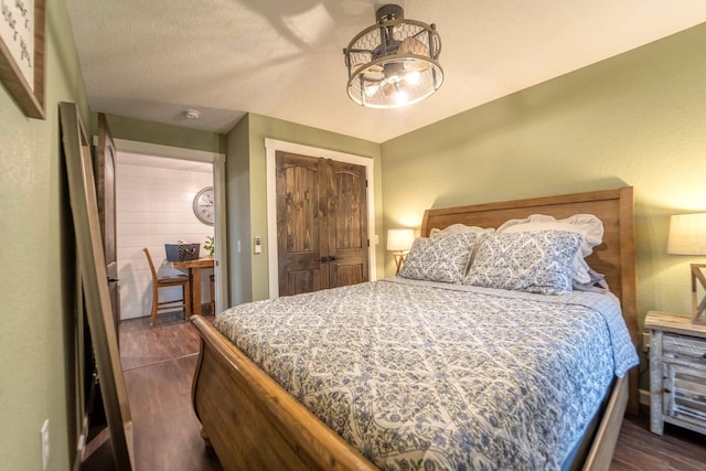 bedroom featuring dark hardwood / wood-style floors, a textured ceiling, and a closet