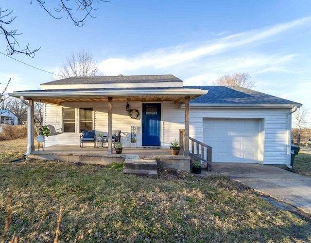 single story home featuring a porch, a garage, and a front lawn