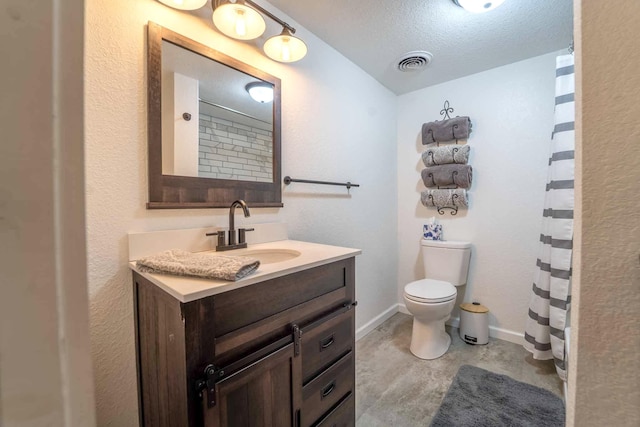 bathroom featuring vanity, toilet, and a textured ceiling