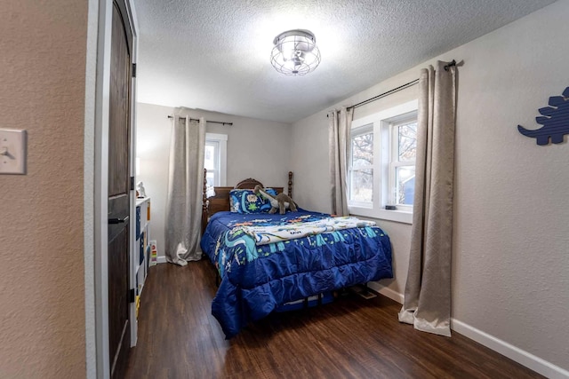 bedroom with dark hardwood / wood-style flooring and a textured ceiling