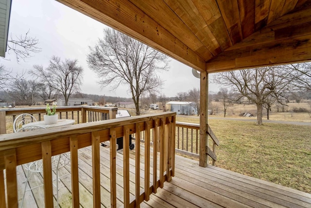 wooden terrace featuring a yard and a storage unit