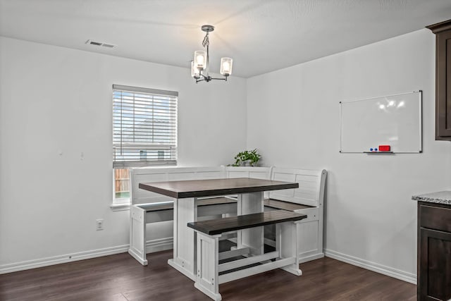 dining space with dark hardwood / wood-style flooring and a notable chandelier