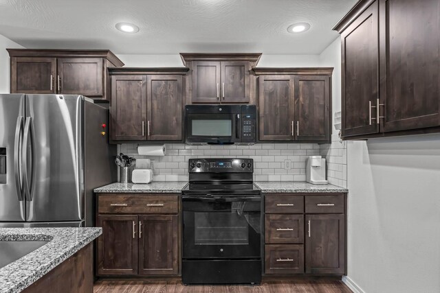 kitchen featuring dark brown cabinetry, light stone countertops, and black appliances