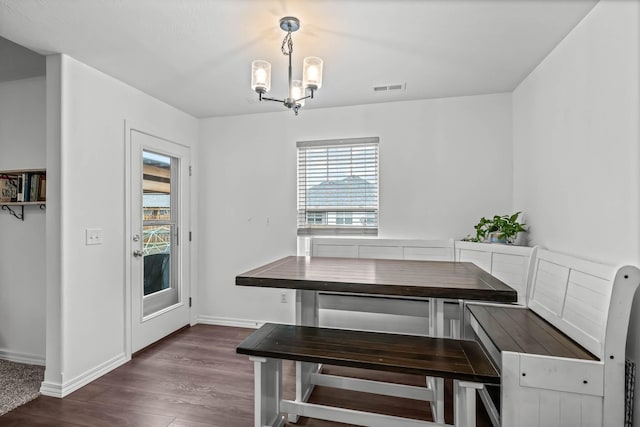 dining room featuring a notable chandelier and dark wood-type flooring