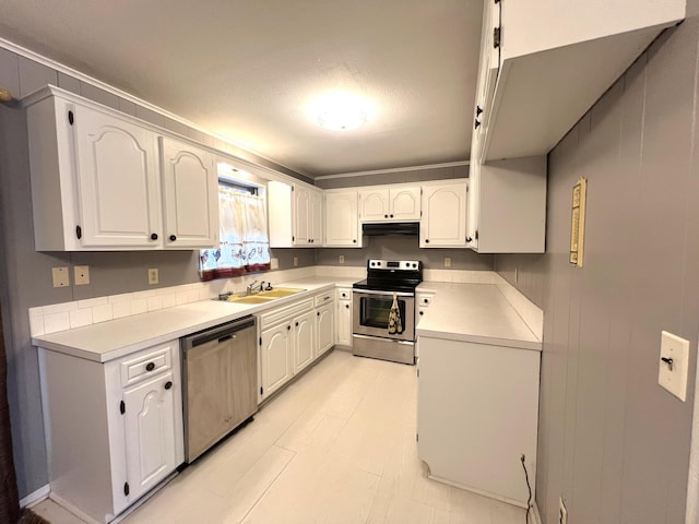 kitchen featuring stainless steel appliances, sink, white cabinets, and light hardwood / wood-style flooring