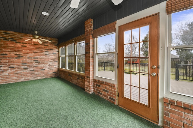 unfurnished sunroom featuring ceiling fan