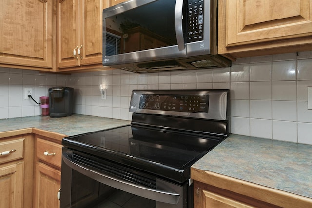 kitchen with backsplash and appliances with stainless steel finishes