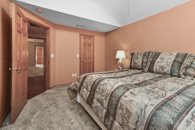 carpeted bedroom with lofted ceiling