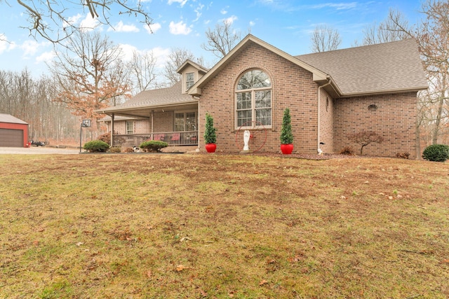 view of front of home featuring a garage, covered porch, and a front lawn