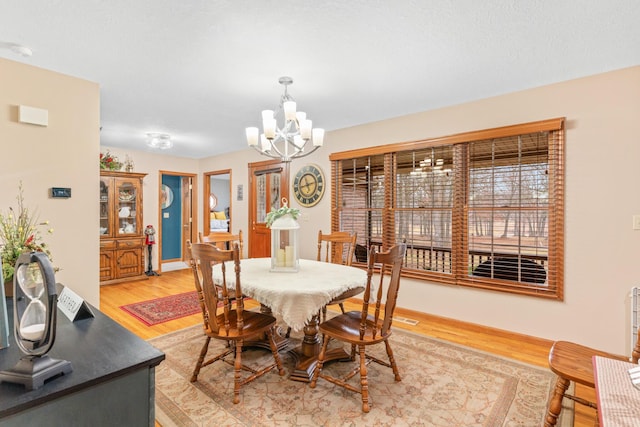 dining area featuring hardwood / wood-style flooring and a notable chandelier