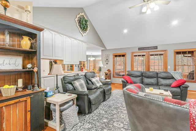 living room featuring high vaulted ceiling, ceiling fan, and light hardwood / wood-style flooring