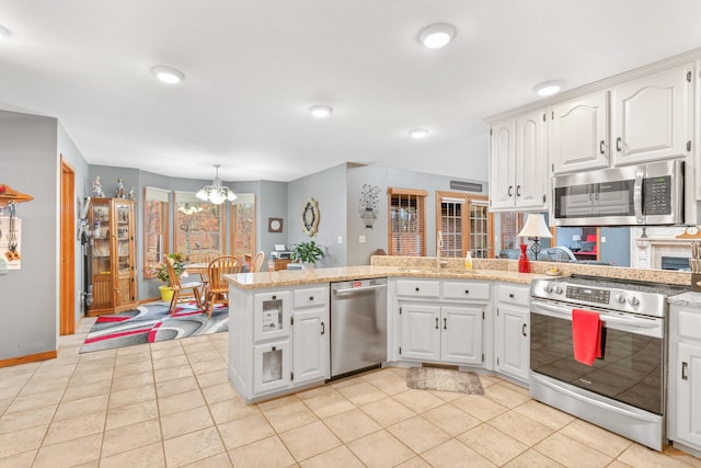 kitchen featuring white cabinetry, appliances with stainless steel finishes, kitchen peninsula, and a notable chandelier